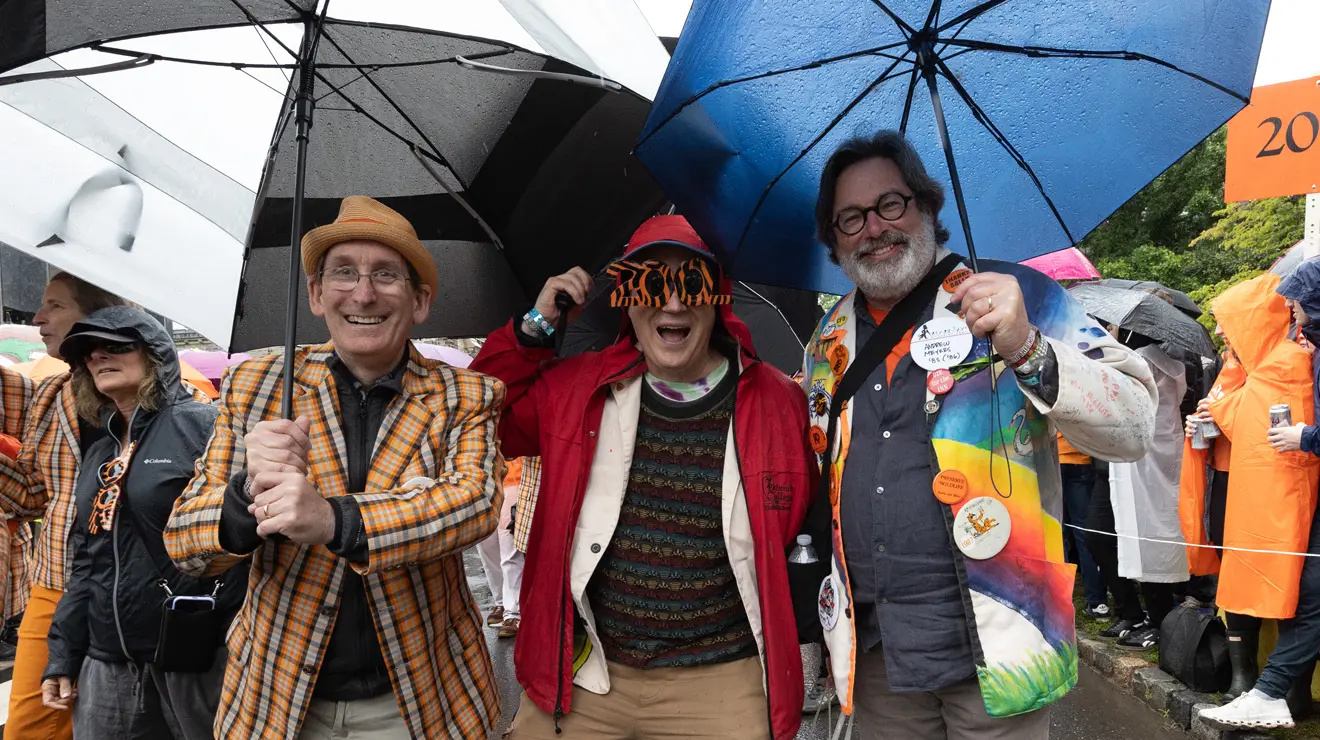 People smile from under umbrellas at the P-rade.