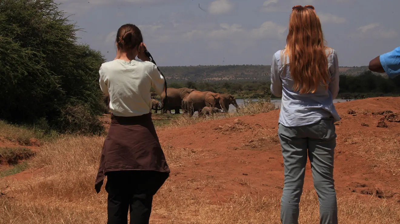 HMEI_gallery_2.jpg HMEI intern Lauren Owens ’27, left, and Megan Sullivan, a postdoctoral researcher, observe a group of elephants at the Mpala Research Centre in Kenya
