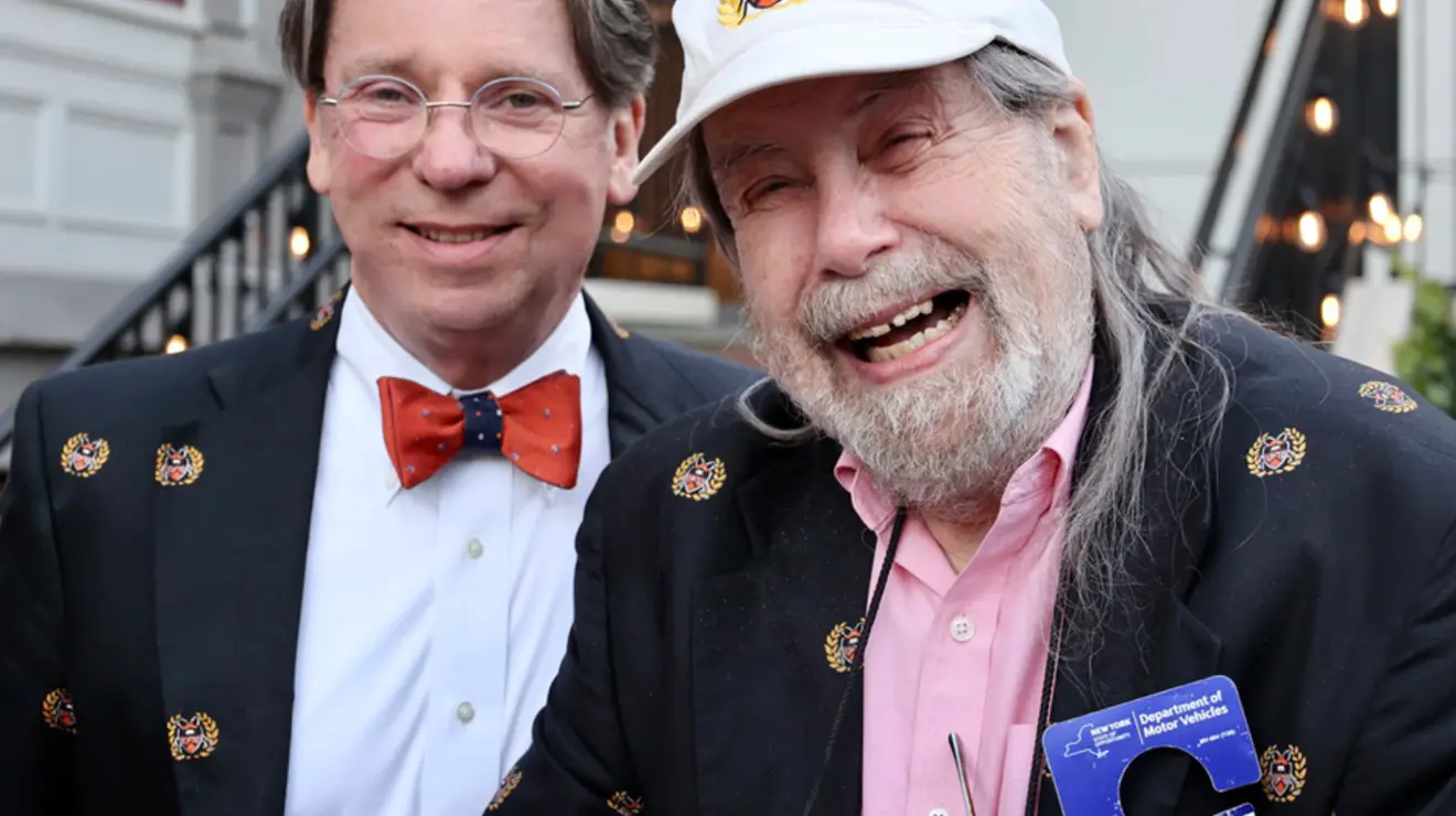 Two men smile for the camera.