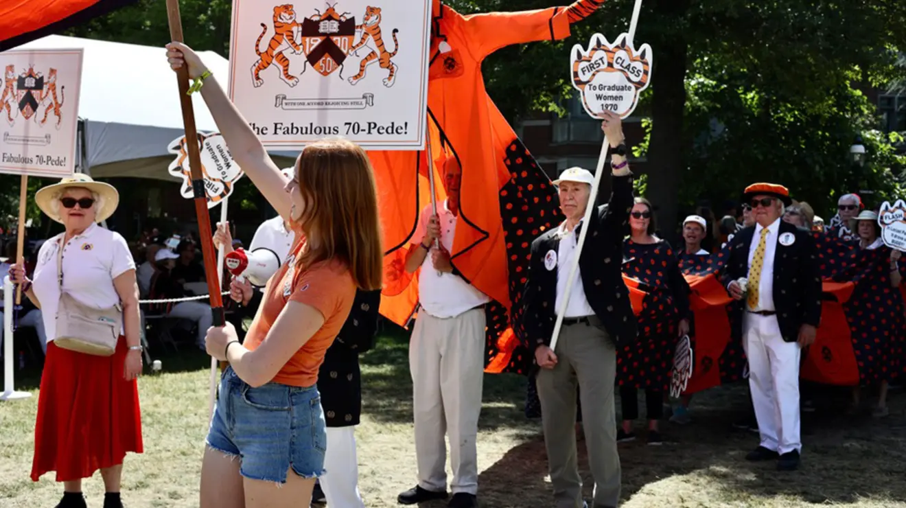 People march in the P-rade holding signs that read "The Fabulous 70-Pede!"