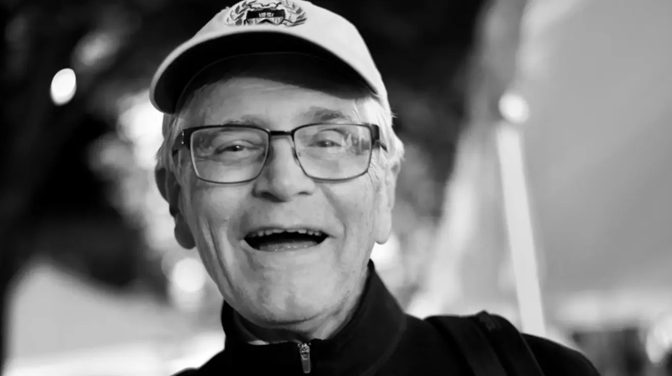 Black and white photo of a man smiling.