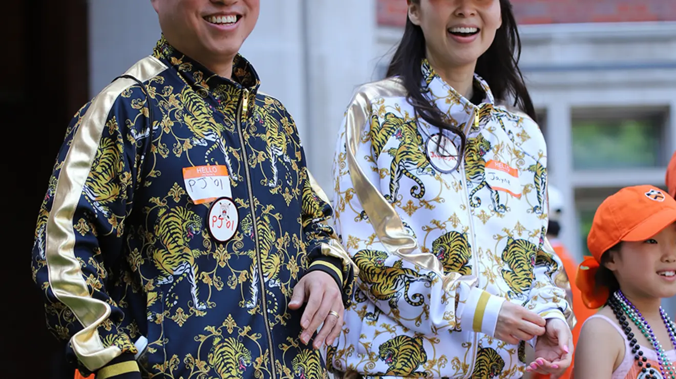 Two people wear jackets with a pattern of tigers.