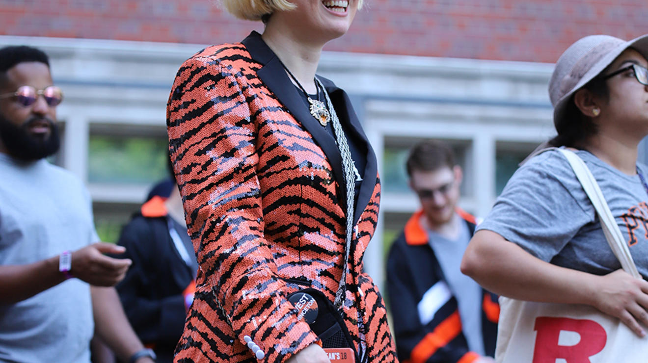 A woman wears an orange-and-black tiger-striped sequined jacket.