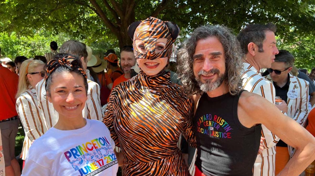 Three people; the center one is wearing head-to-toe tiger stripes. 