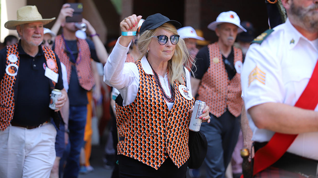 A woman with orange nail polish raises her fist during the P-rade.