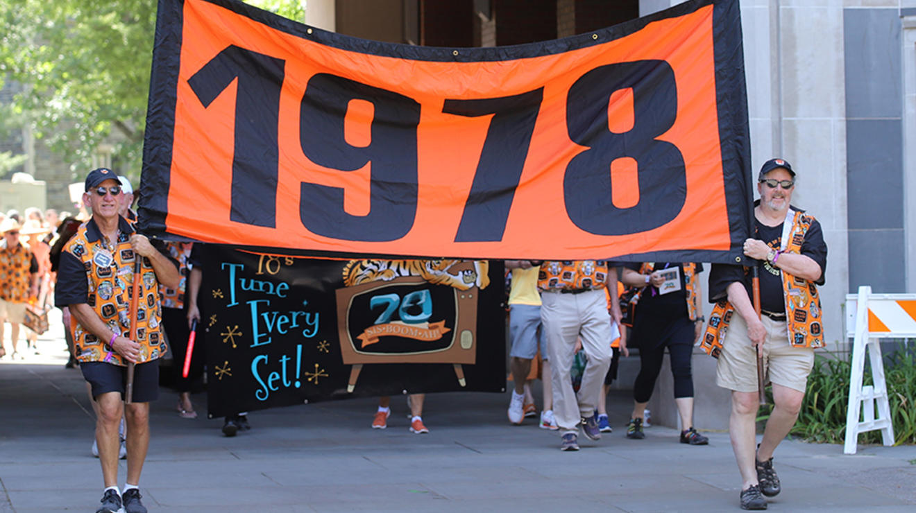 Two guys carry the "1978" banner.