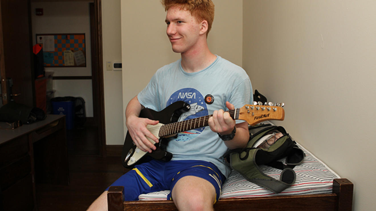 Greyson Sapio ’26 of Mays Landing, New Jersey, strums a guitar.