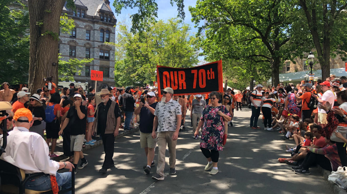 A sign carried in the P-rade reads "Our 70th."