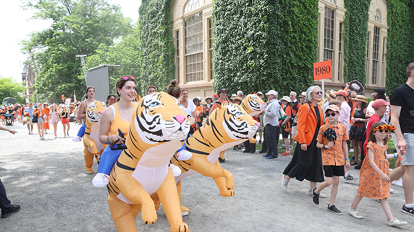 Alumni "ride" big inflatable tigers in the P-rade.