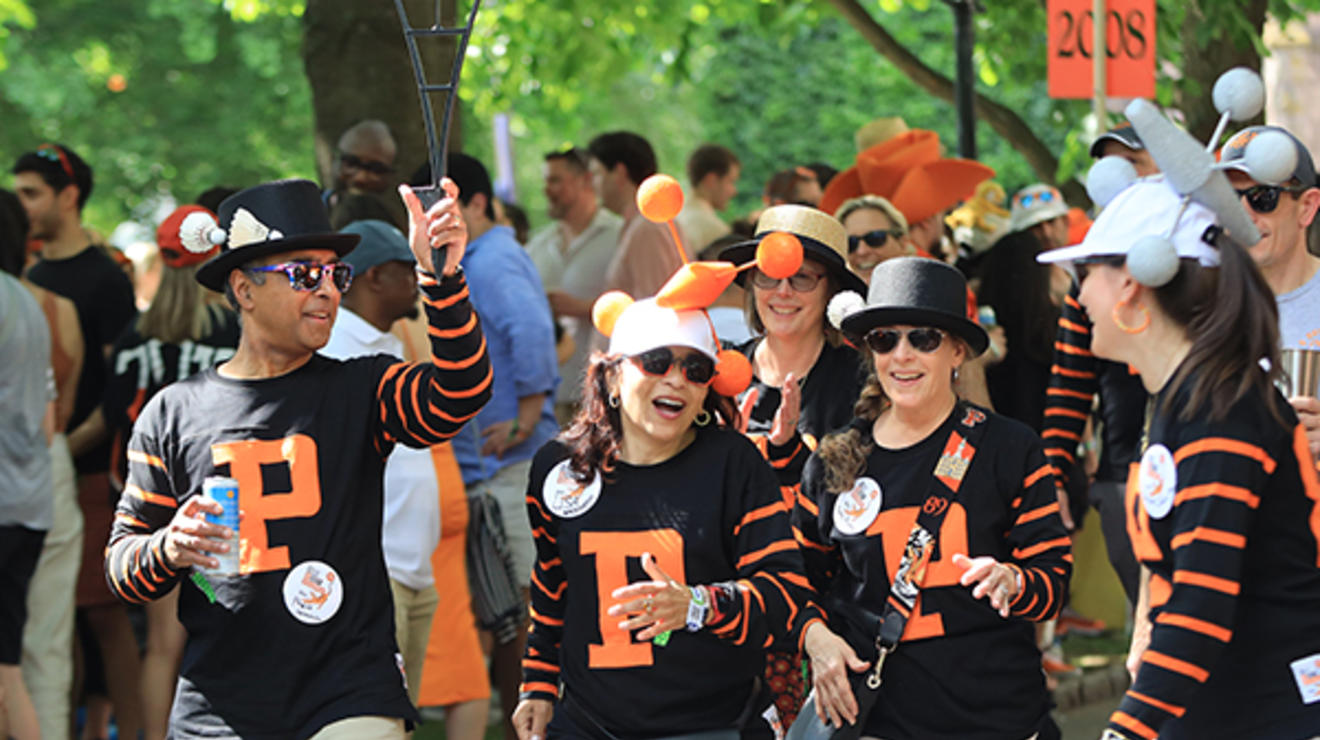 Friends wearing black shirts with the letter "P" in orange march in the P-rade.