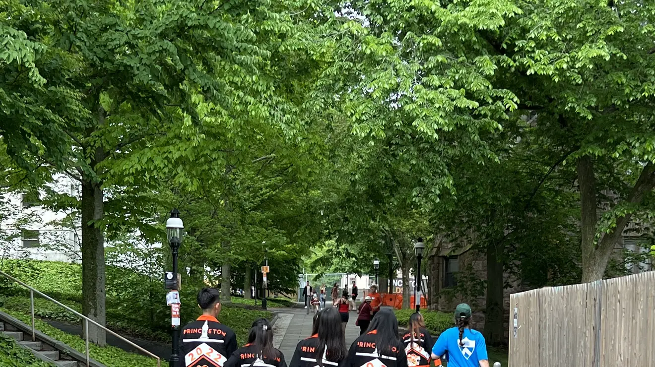 StudentsWalking_liz.jpg Four students in the Class of 2022 walk down a stone path with their class jackets on.