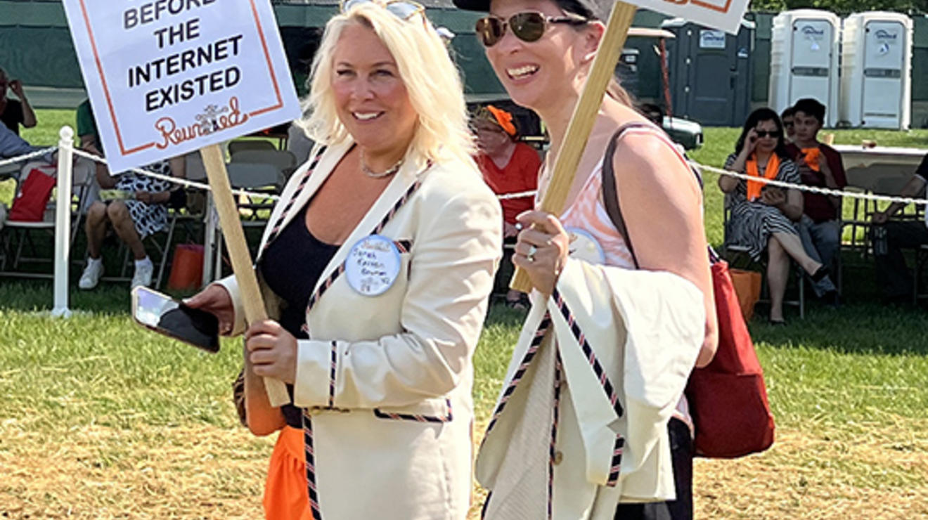 Two women carry signs that read, "At least I did all my stupid stuff before the Internet existed," and "The older I get, the earlier it gets late."