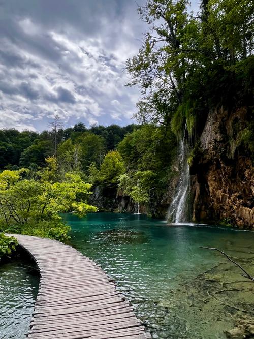Waterfall leading into the green and blue waters of Lake Plitvice