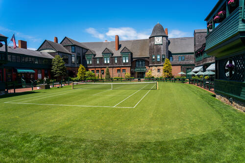 Tiger-Travels_Newport-Rhode-Island_Jennifer-Roosth_Tennis-Hall-Fame.jpeg View of the Tennis Hall of Fame a building with a green tennis court set in front.