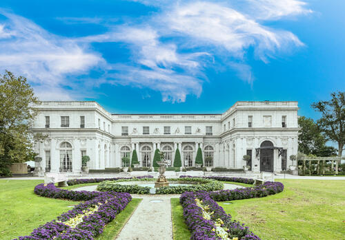 Tigers-Travels_Newport-Rhode-Island_Jennifer-Roosth_Rosecliff.jpeg Rosecliff mansion set in the back with a stone walkway surrounded by purple flowers