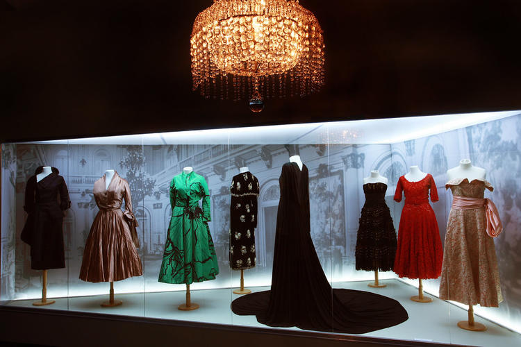 A series of dresses inside a display case. 