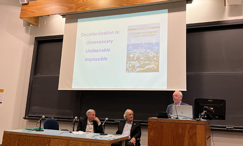 Bruce Everett ’69 shows a slide reading, “Decarbonization is: unnecessary, undesirable, impossible.”