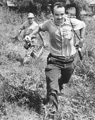 A sheriff’s deputy pursues Matt Herron ’53 during a march in Philadelphia, Miss., in 1966.