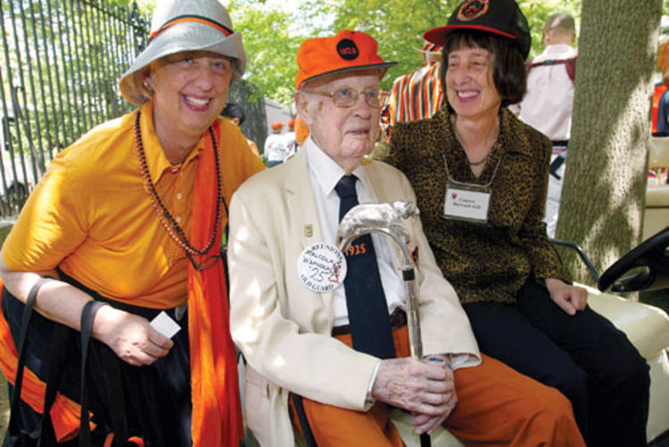 For the fifth time, Malcolm Warnock ’25, with his daughters, Margaret Carlough, left, and Eleanor Warnock, carries the silver-topped Class of 1923 Cane.