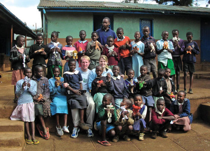 Hunter Woolley ’98 and Ann Ellis Woolley ’01, center, with students at the RAFIKI school in Kibera, Kenya.