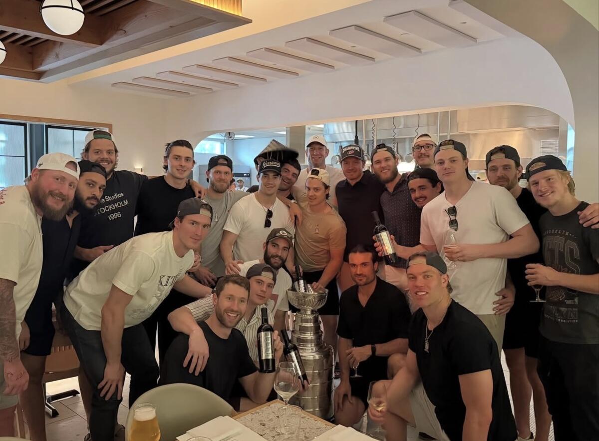 Eric Robinson ’18, at right in a white shirt, celebrates with his teammates and the Stanley Cup at restaurant in Raleigh, North Carolina.