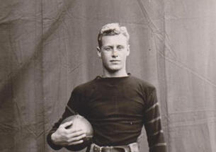 Black and white photo of Hobey Baker holding a football. 