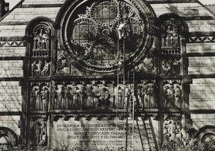 Sepia-toned photo of ladders leaning up against a stained-glass window.