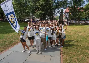 Students wearing Yeh College shirts cheer in front of Fitzrandolph gate.