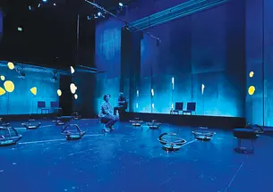 Robots scatter around a room lit with blue light.