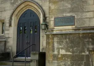 A door on a Gothic building next to a sign reading "Dickinson Hall."