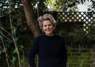 Portrait of Author Eliza Griswold standing in front of greenery. 