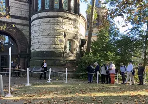 Faculty members standing in line outside a doorway