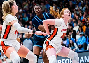 Four players vying for position to rebound the ball in a basketball game