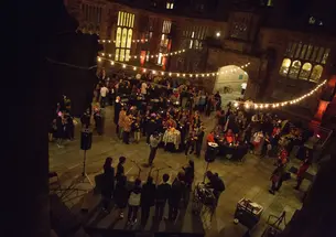 People gather under fairy lights strung across the East Pyne courtyard.