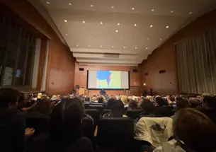 Mosab Hassan Yousef sits in front of a crowd in McCosh 10.