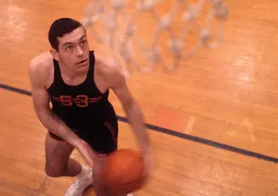 Bill Bradley ’65 looks up at the basketball net hanging in the foreground.