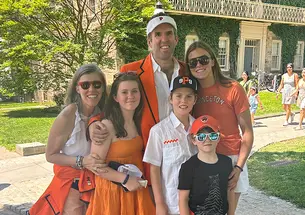 Two parents and their four children, dressed in orange for Princeton Reunions.