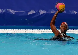 Water polo goalie Ashleigh Johnson ’17 palms the ball in her right hand and holds it over her head.