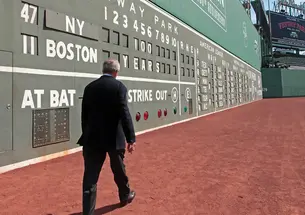 Larry Lucchino ’67 walking along Boston's Green Monster at Fenway Park