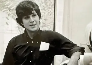 Tom Hanks ’66 leans on a piece of geological equipment.