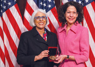 Professor Bonnie Bassler, right, receives  the National Medal of Science from  White House adviser Arati Prabhakar.