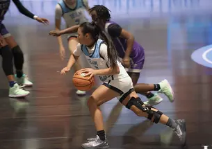 Ashley Chea ’27 dribbles down the court in her blue-and-white high school basketball uniform.