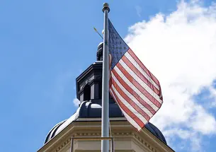An American flag flies in front of the cupola of Princeton’s Nassau Hall.