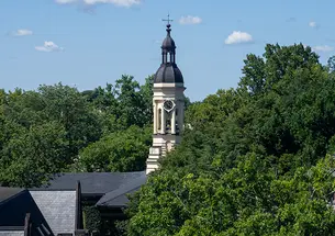 The cupola of Princeton's Nassau Hall peeks up from surrounding leafy trees.
