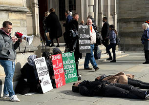 People walk into the Princeton chapel past a pro-Palestinian protest where two people are laying on the ground.