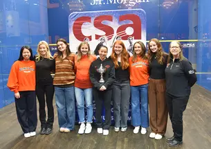 Members of the Princeton women's squash team posing on a squash court in New York City