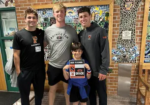 Baseball players, from left, Grant Werdesheim ’28, Jake Kernodle ’27, and Andrew D’Alessio ’25 catch up with a fourth-grader at Johnson Park Elementary.