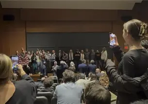 Attendees crowd the stage during an emotional moment during a speech by the former prime minister of Israel.