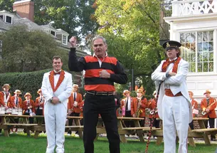 Tom Meeker ’56 leads a locomotive cheer in 2006, with student conductor Charles Pence ’07 and drum major Charlie Bergen ’07 looking on
