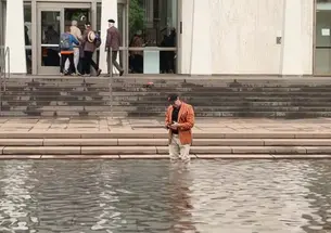 PAW writer Mark F. Bernstein '83 stands in the reflecting pool of the Fountain of Freedom